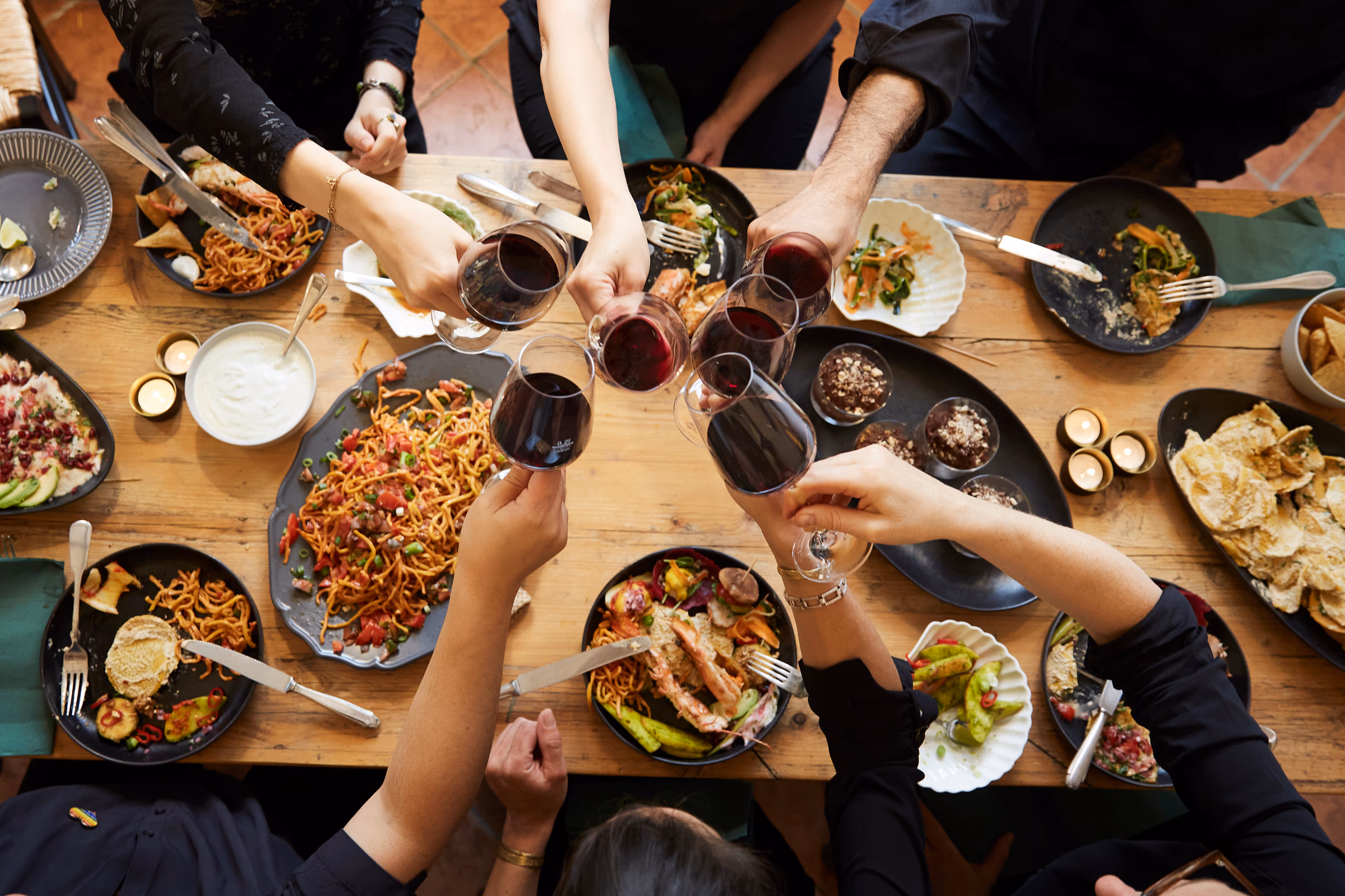 Gäste stoßen über der gedeckten Tafel an