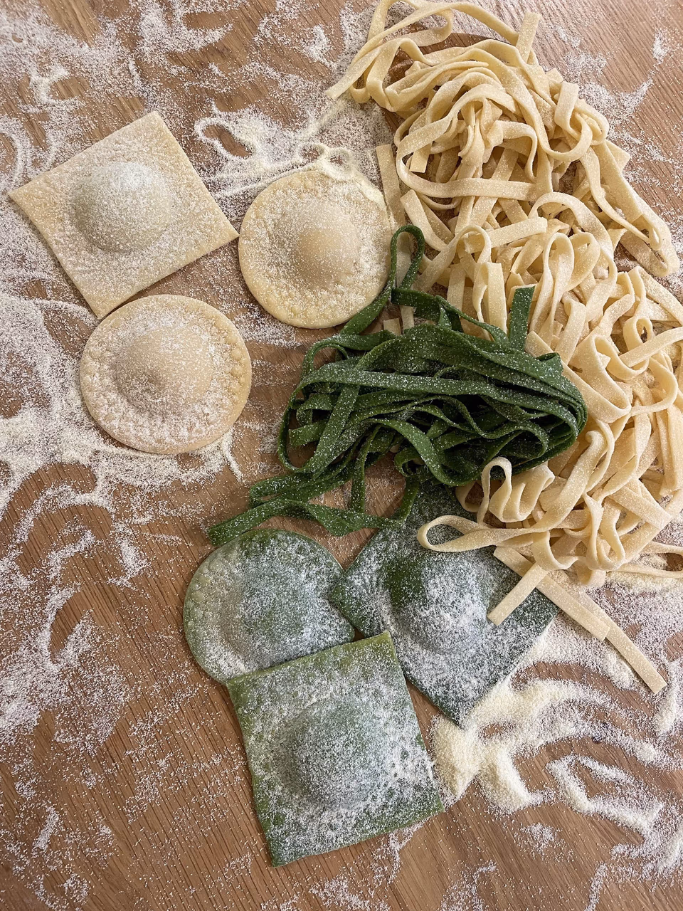 Frische Tagliatelle und Ravioli auf bemehlter Arbeitsfläche