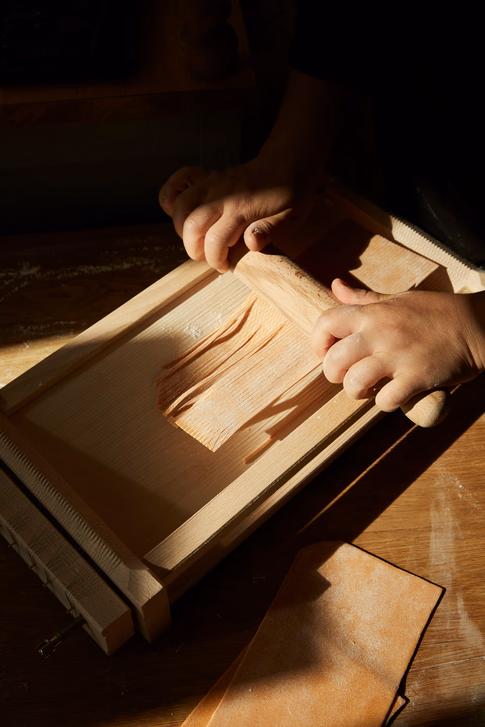 Frische Pasta wird an der Chitarra geschnitten