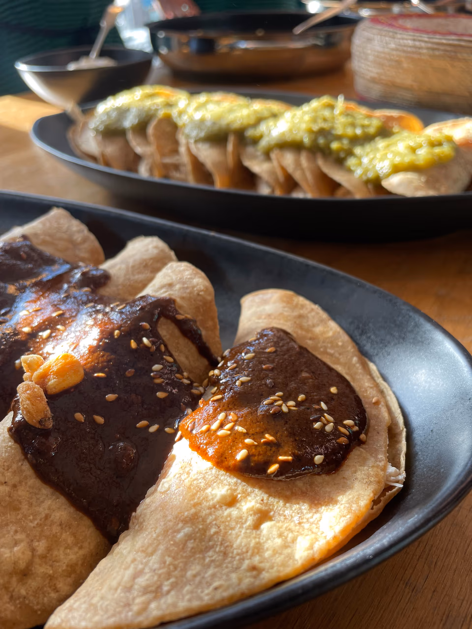 Enchiladas con Mole auf einem dunklen Teller angerichtet