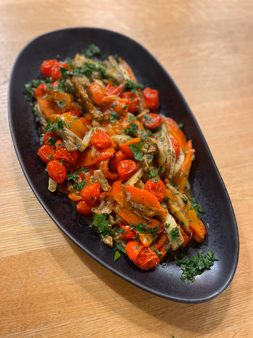 Gemüseplatte mit Paprika und Kräutern auf ovaler Servierplatte