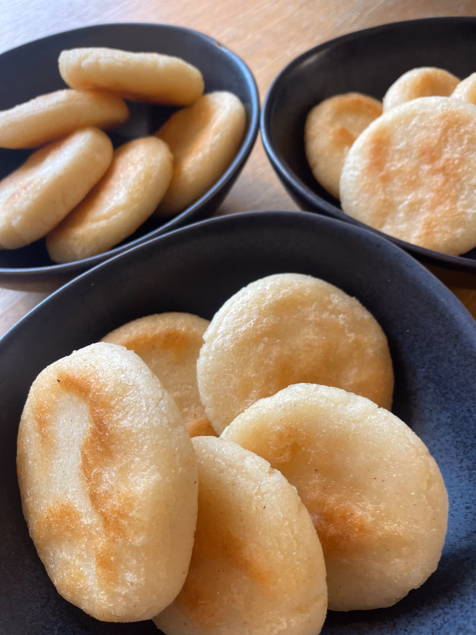 Frisch gebackene Arepas in dunklen Schalen